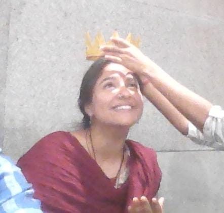 Pallavi being crowned with a golden paper crown